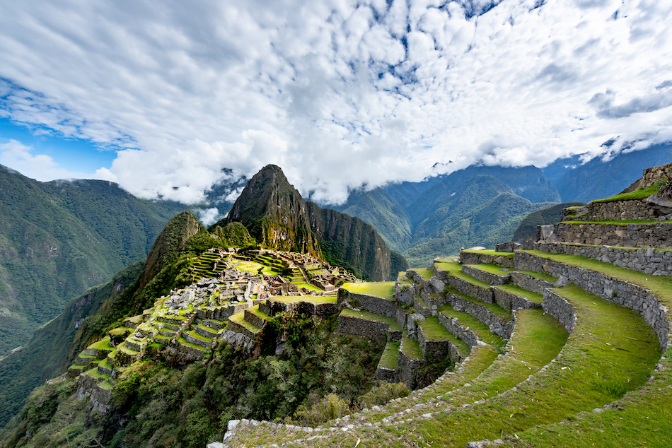 An overhead view of misty Machu Picchu green mountains