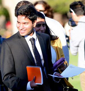 Man in suit holding brochures in a conference setting