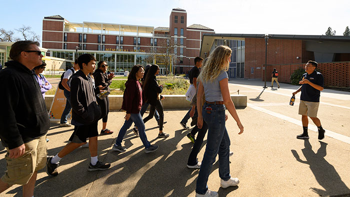 Junior Zach Luis leads a tour group past the Memorial Union.