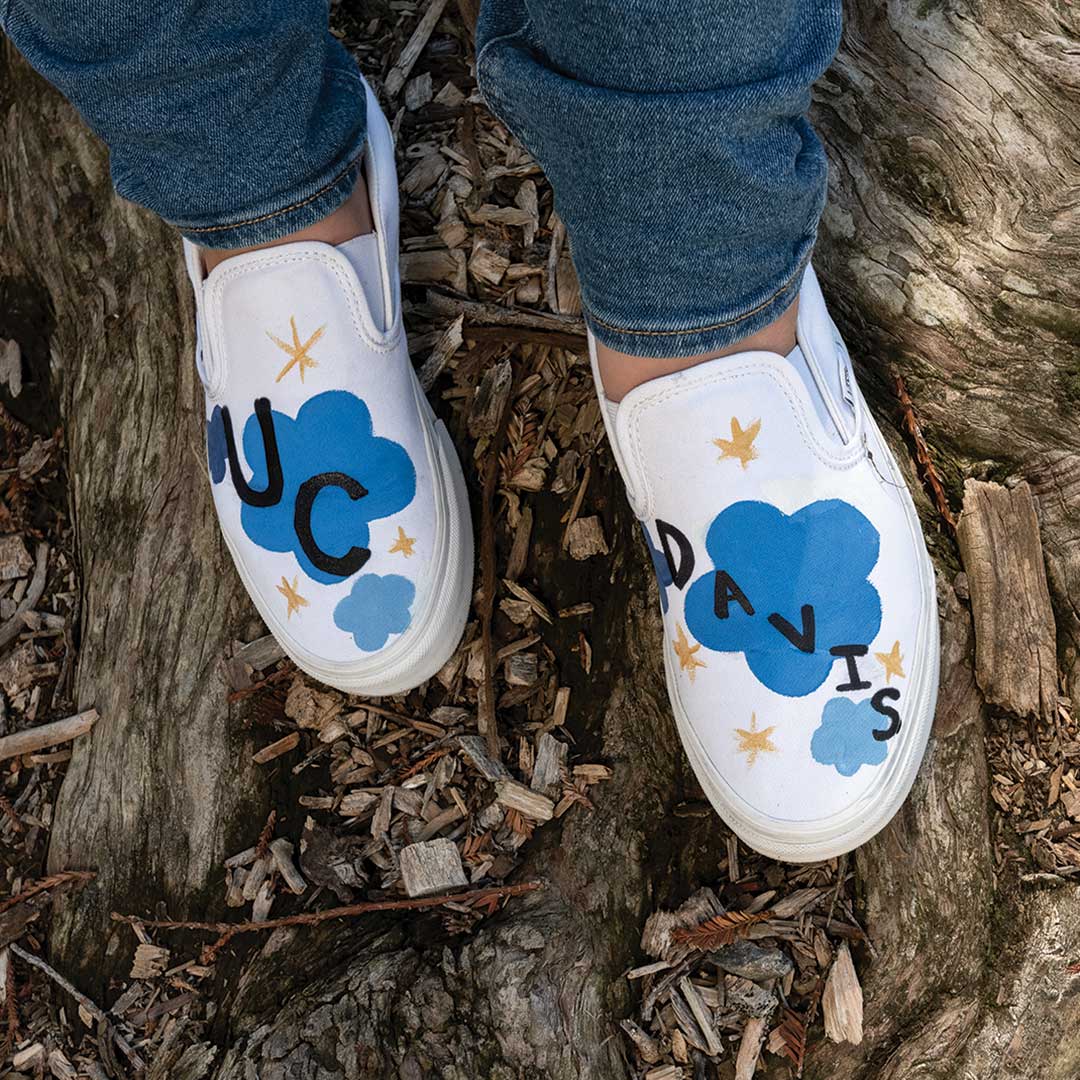 Shoes decorated with clouds, stars and the words UC Davis