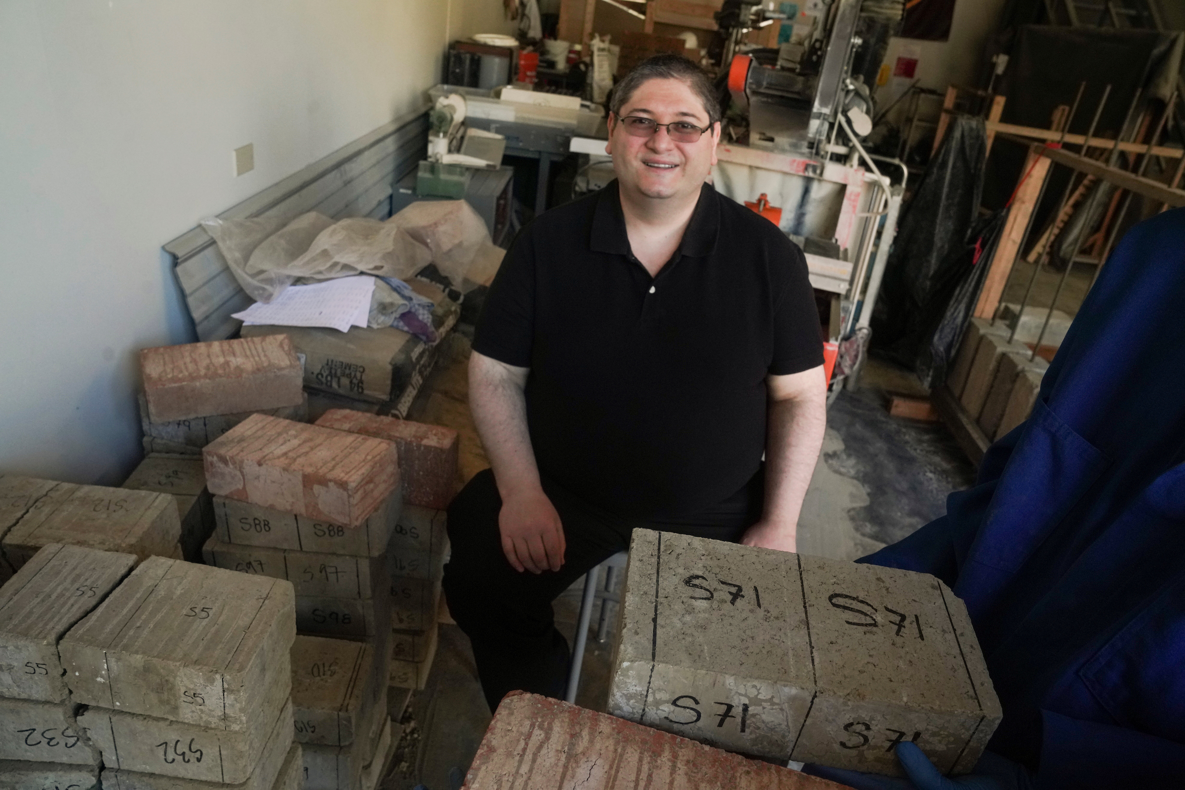 Professor Michele Barbato in middle of pile of earthen blocks