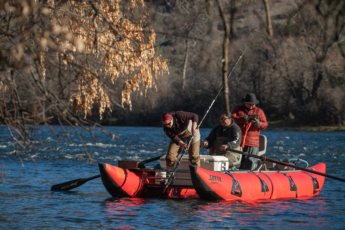 Yurok Tribal Fisheries members in red pontoon boat float Klamath River