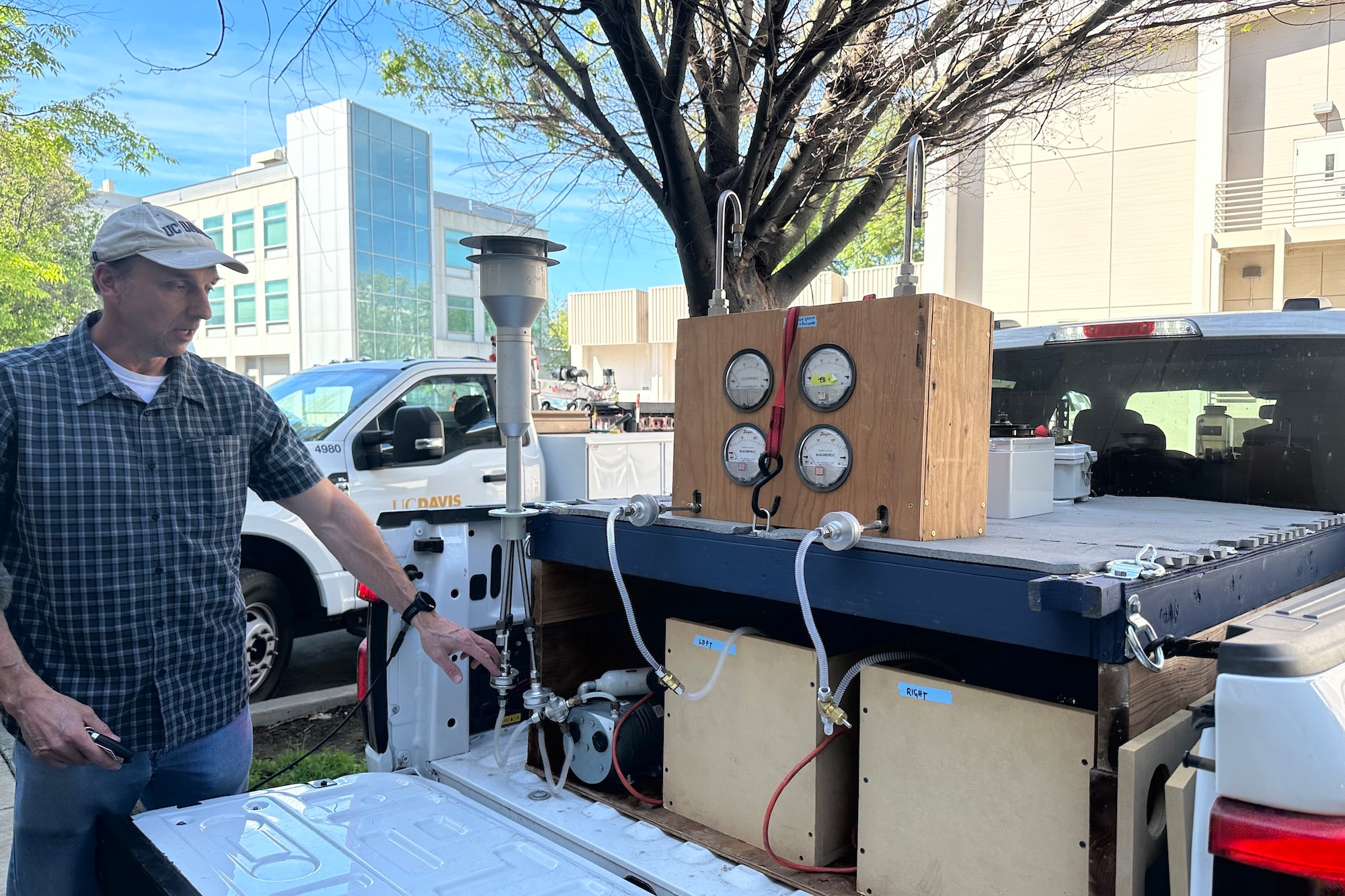 UC Davis Chemical and Environmental Engineer Michael Kleeman beside wooden gauge panel and tubing mounted on an electric pickup truck bed. This is his mobile air quality lab. The devices measure air particles. (Emily Dooley / UC Davis)