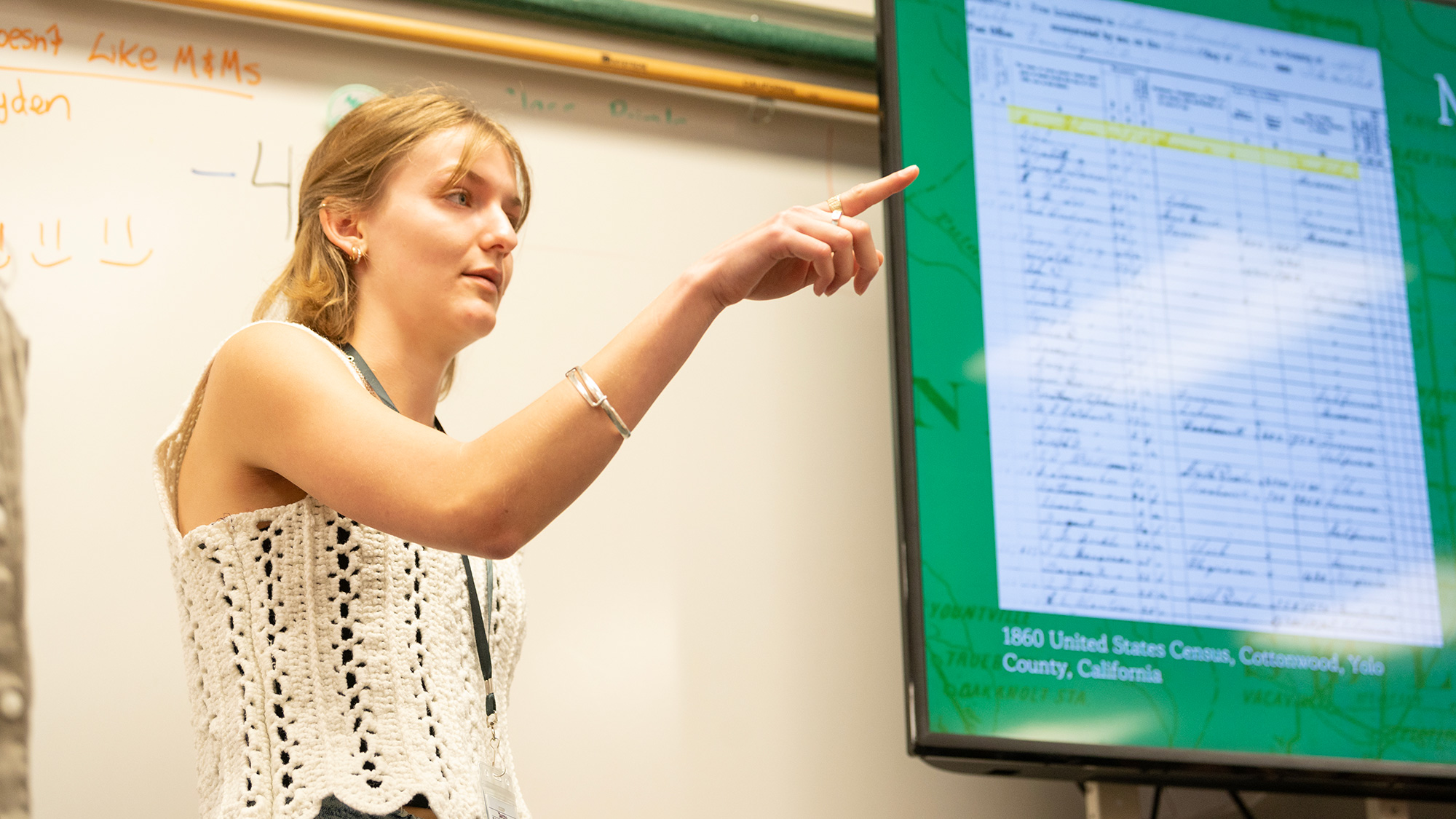 A college student interacts with kids in an elementary school classroom
