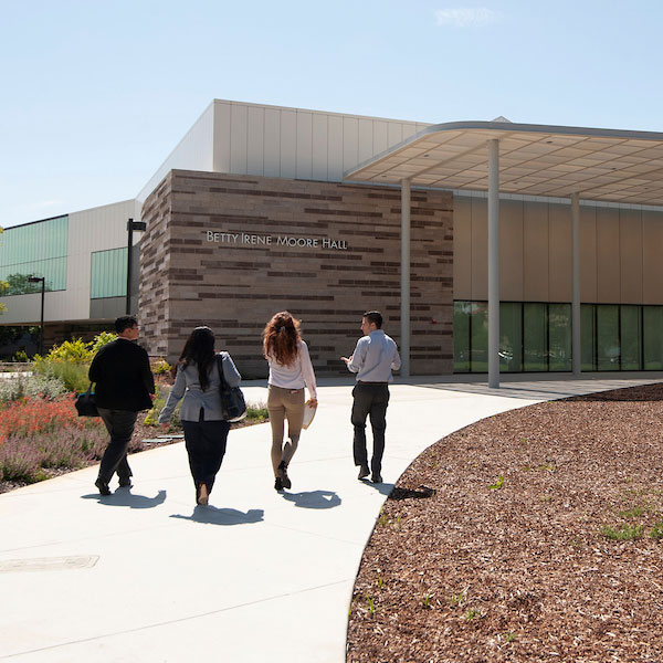 Students walk toward the Betty Irene Moore School of Nursing entrance