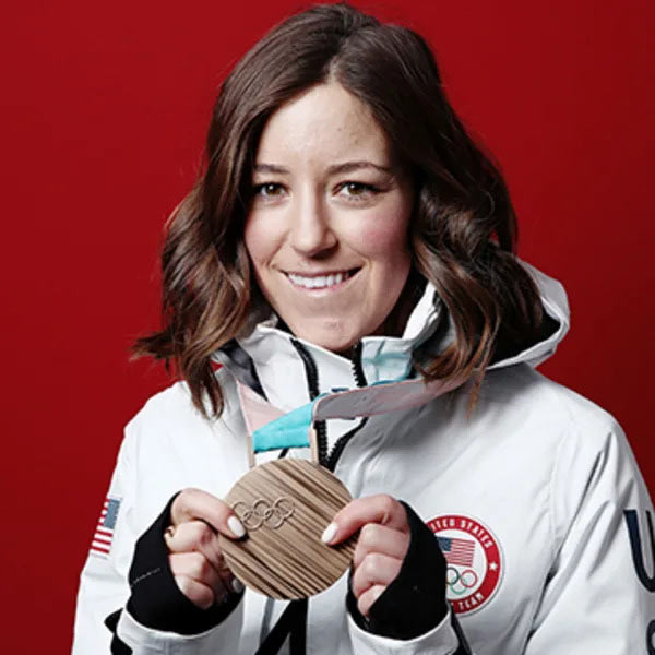 Brita Sigourney showing off bronze medal, on ribbon, around her neck