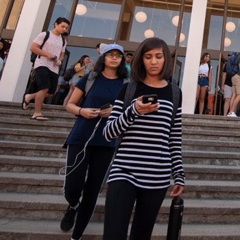 students walking down steps in front of a building