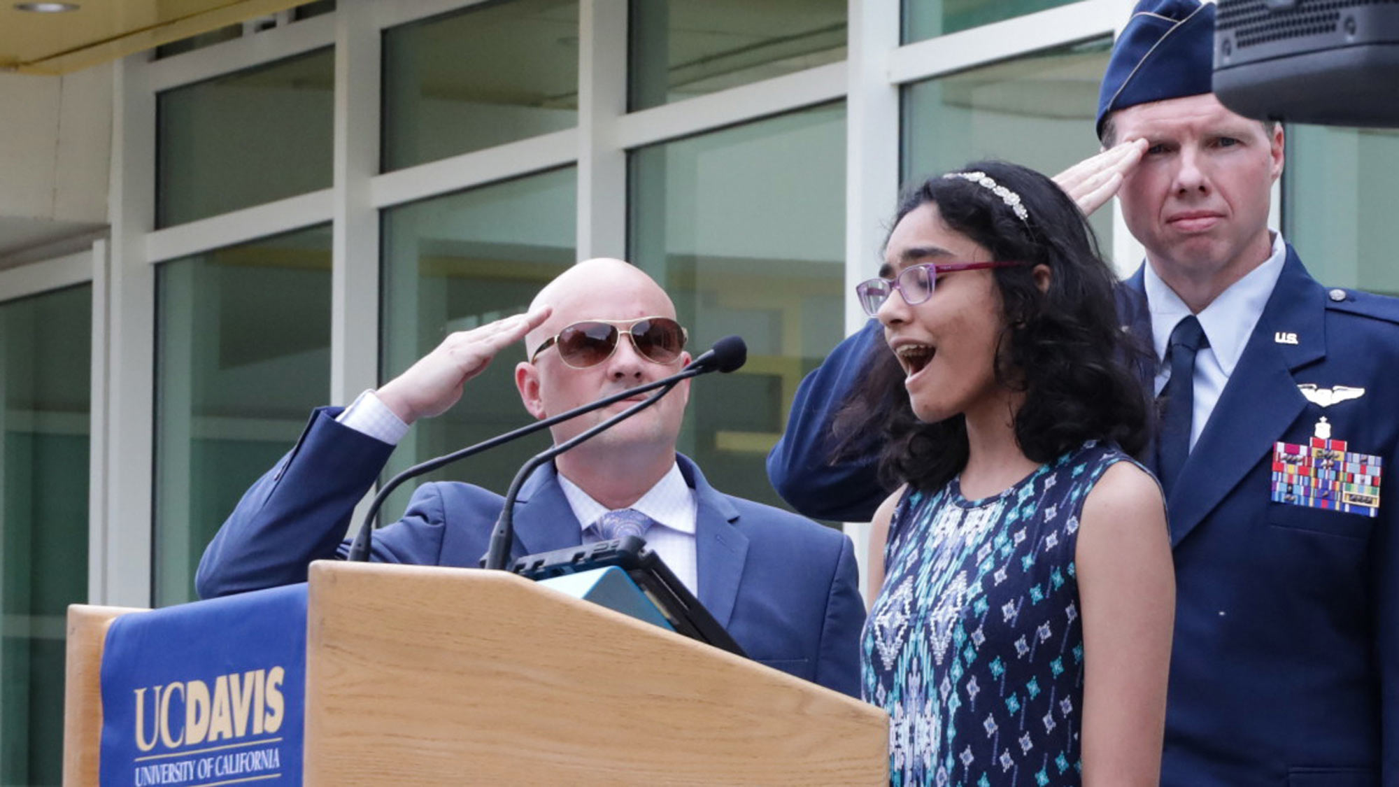 Woman sings national anthem from podium