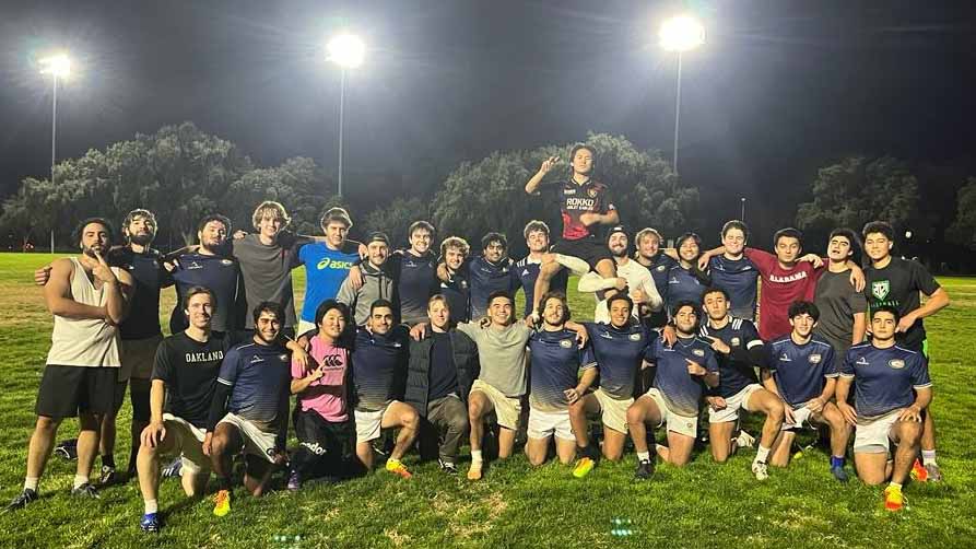 Rugby players pose for photo on field