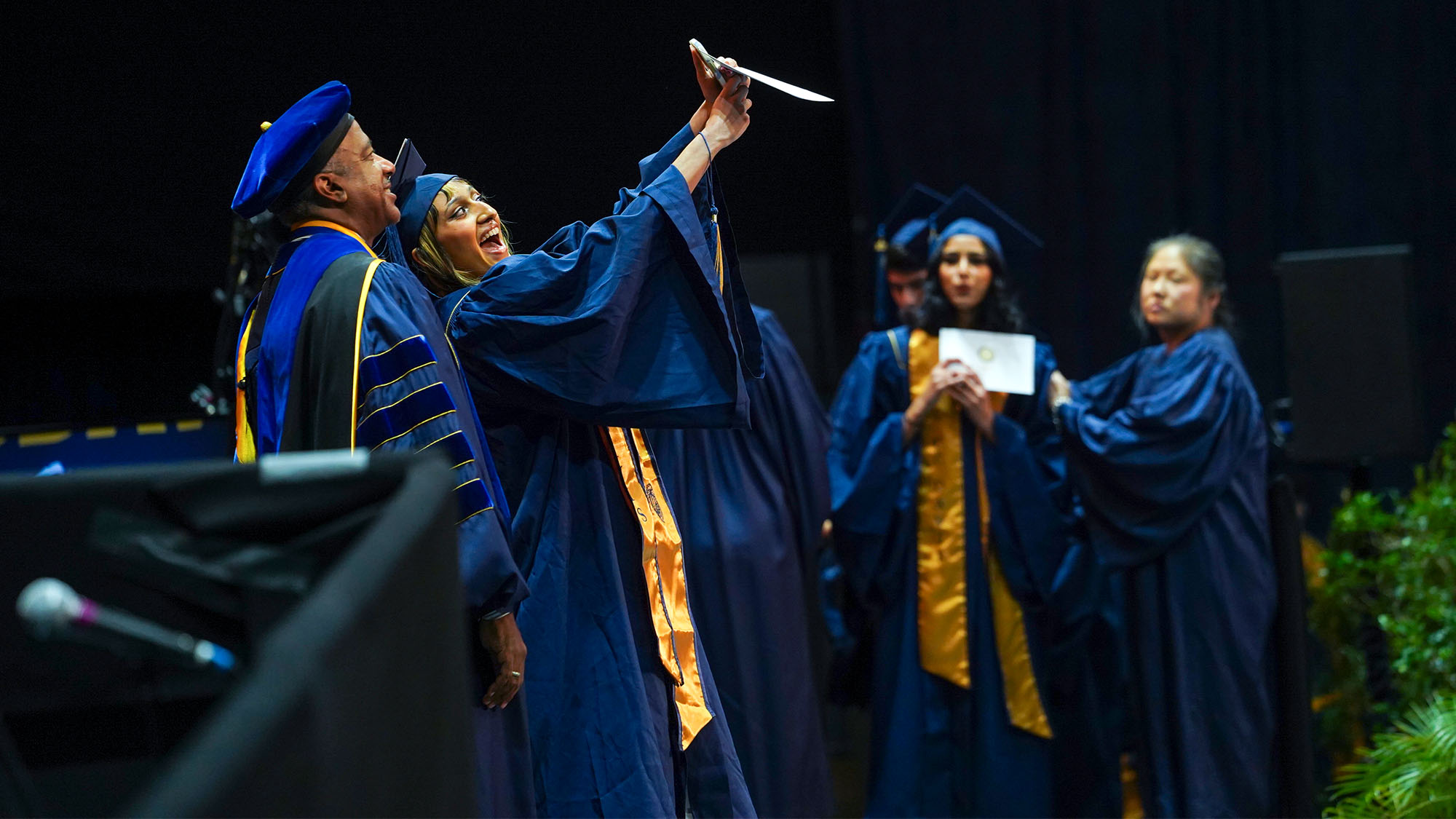 Student takes selfie with chancellor on graduation stage