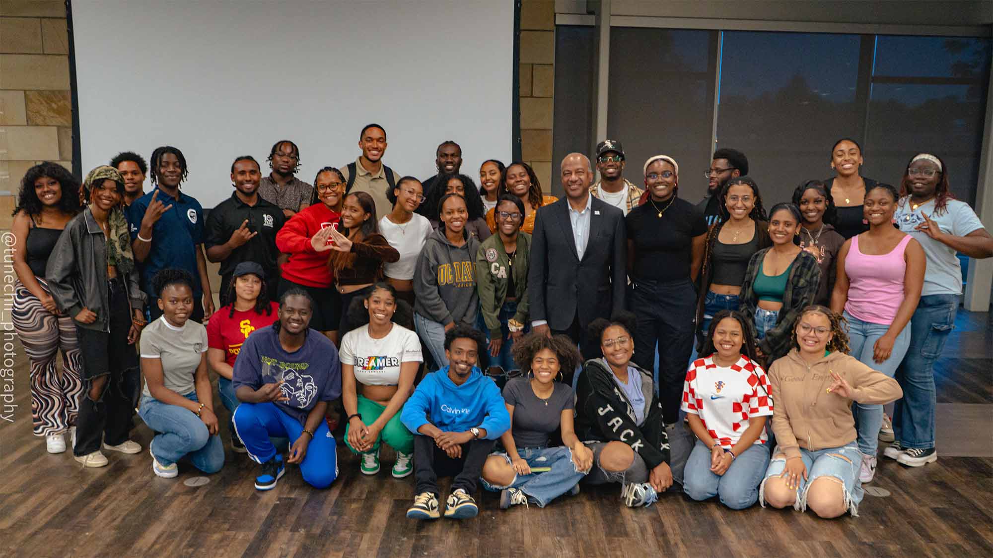 Chancellor Gary S. May poses for photo with group of students.