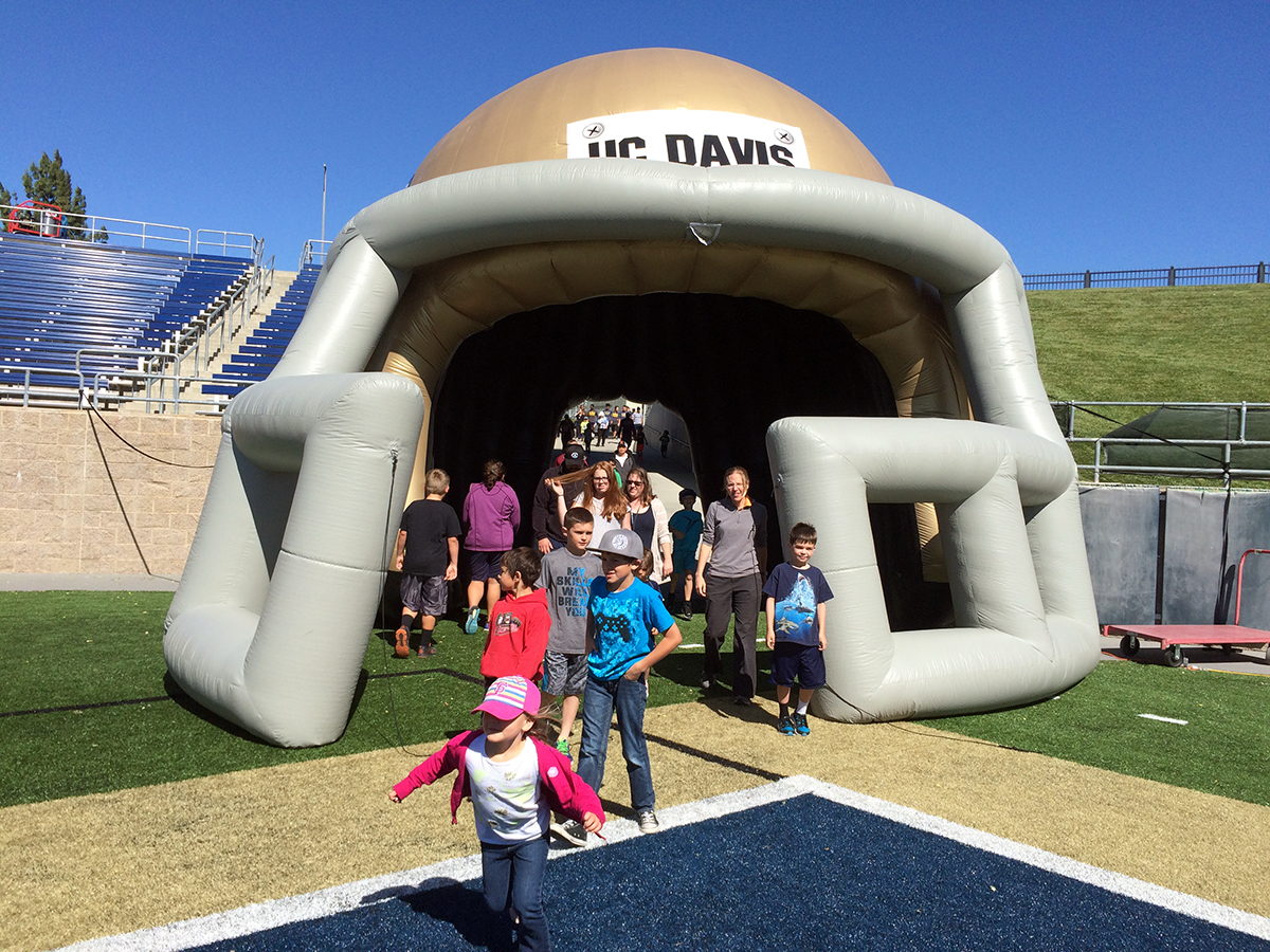 Children run onto the field at Aggie Stadium.