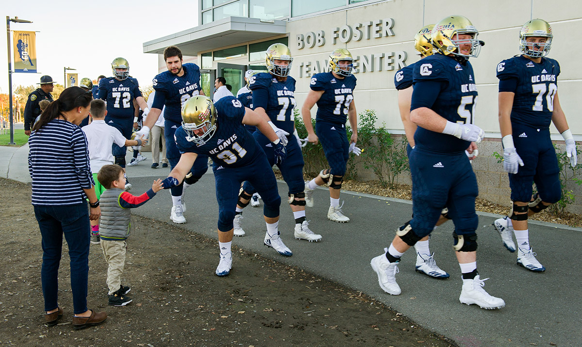 Football players walk toward the field