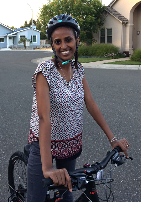 Woman stands with bike.