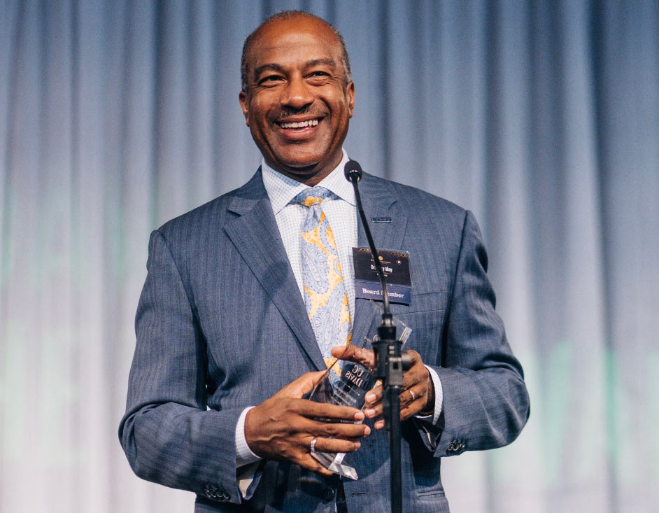 Chancellor May at microphone, with award.