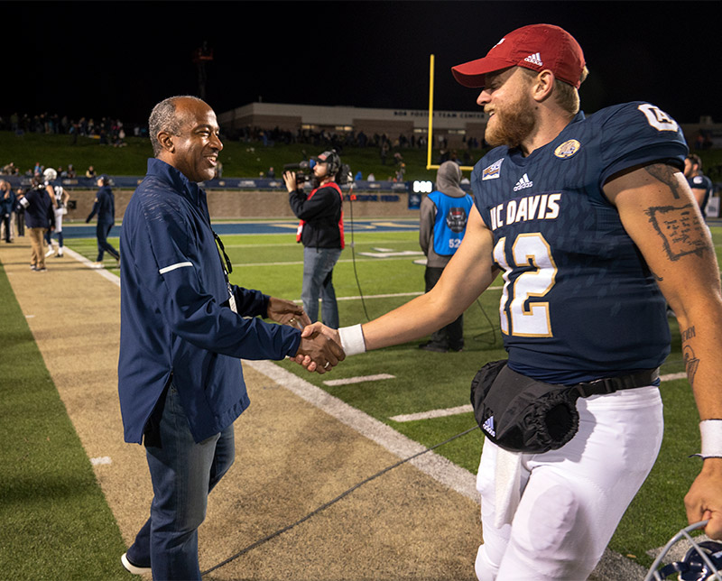 Chancellor Gary S. May congratulates sophomore quarterback Brock Johnson.