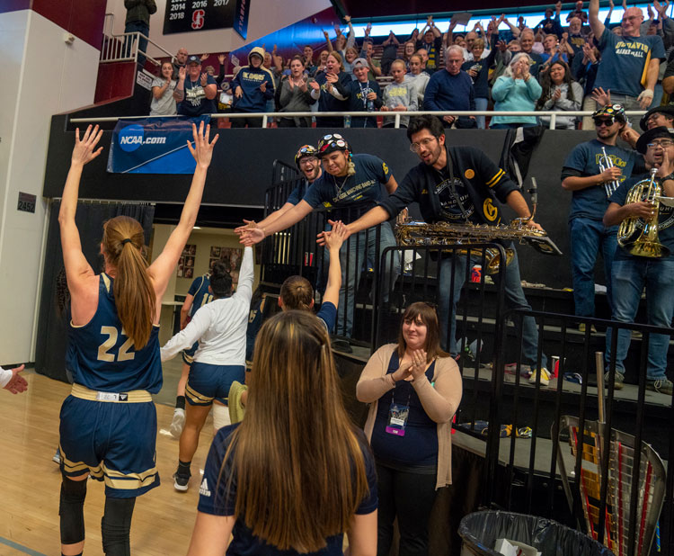 Player exits court with arms held high.