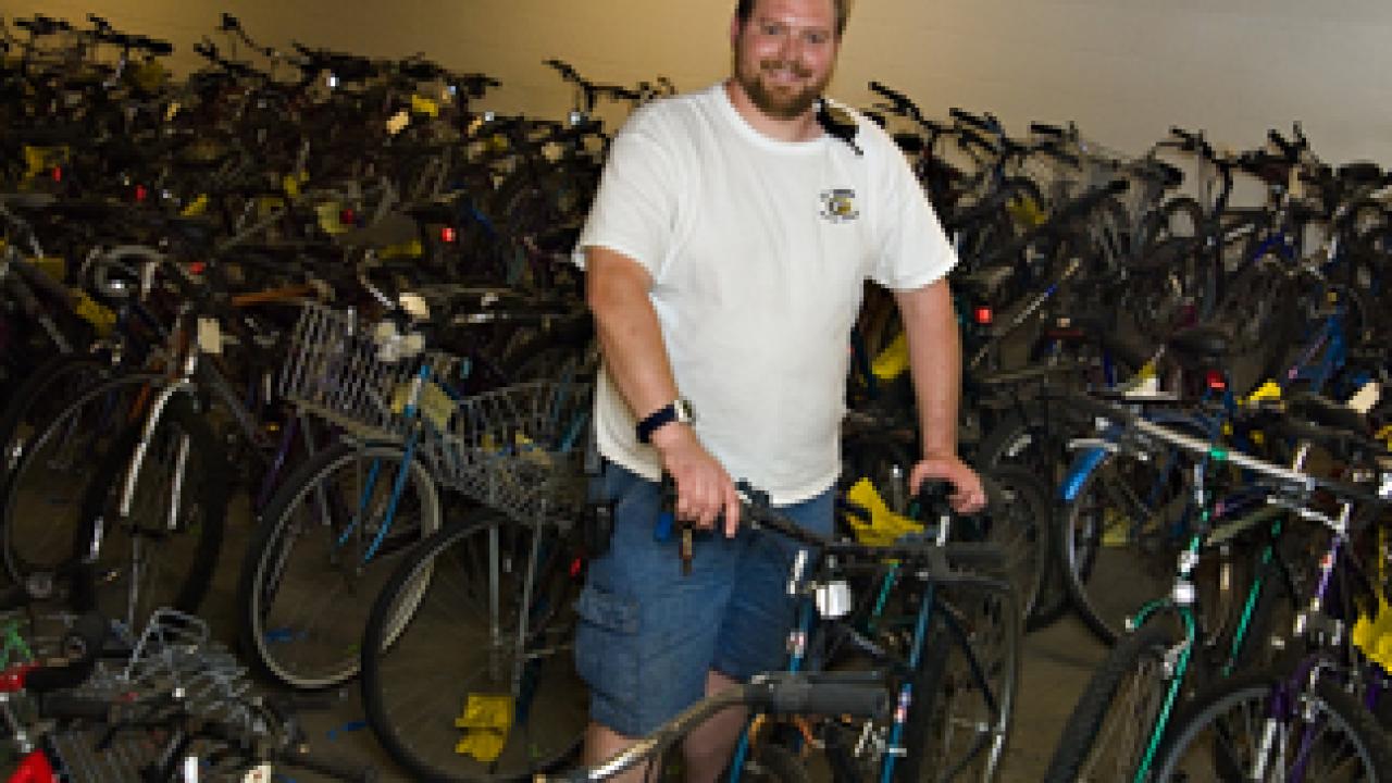 Scott Hutchison, Bicycle Program assistant, shows off some of the more than 350 bicycles that are due to go up for auction May 3.