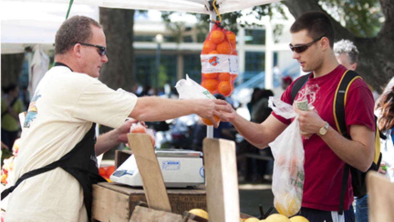 Photo: An East Quad Farmers Market vendor makes a sale.