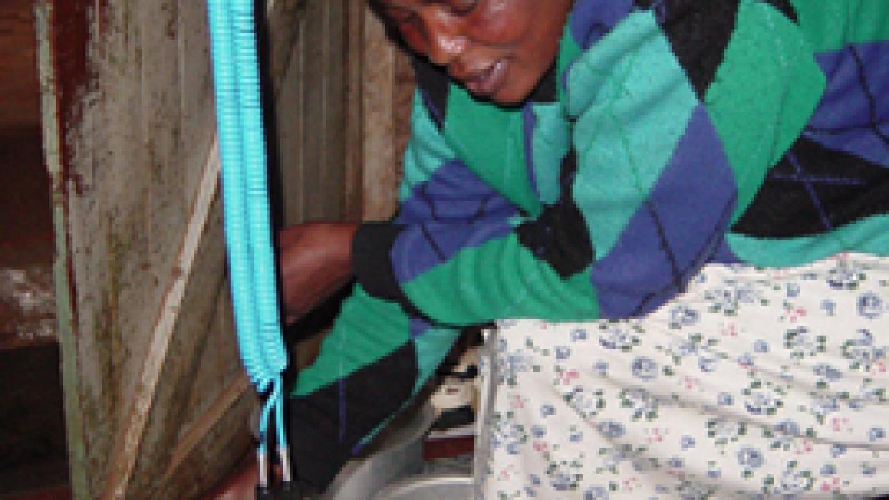 In the Kibera slum outside Nairobi, Kenya, an unidentified community health worker demonstrates the flash-heating process -- using a glass jar of cow'