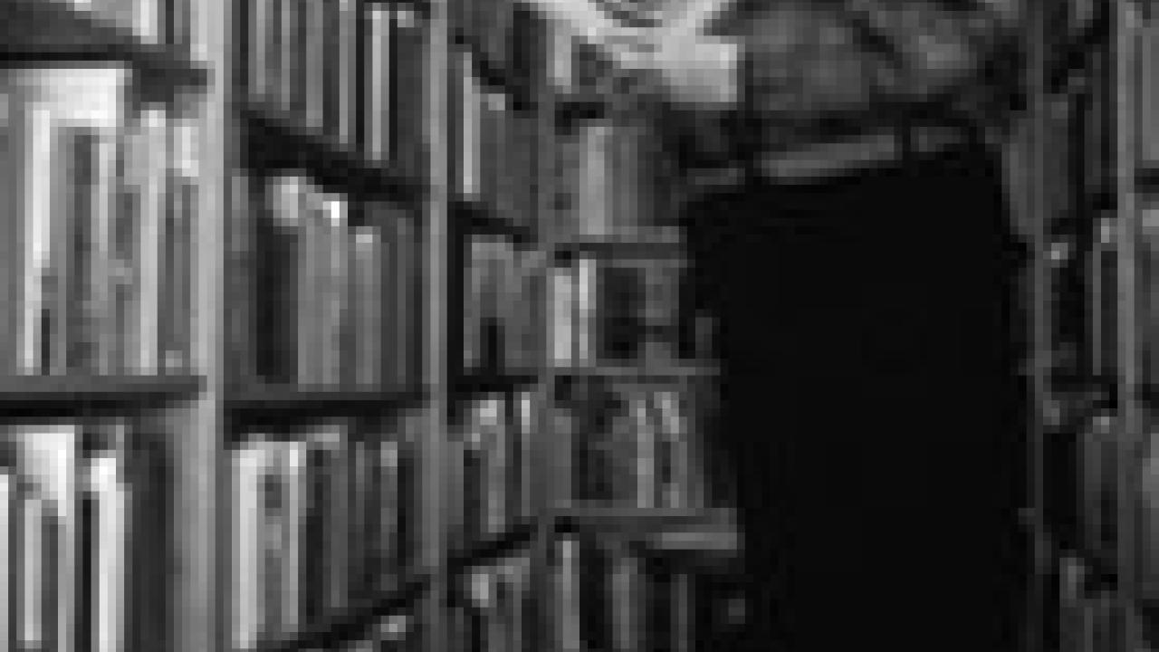 Above, Michael Harrison, reads one of his 21,000 books in 1984. Harrison, who passed away in April 2005 at the age of 107, donated his Western book collection to campus. On the front, Michael Westergard&rsquo;s bronzes of the history, wildlife and p