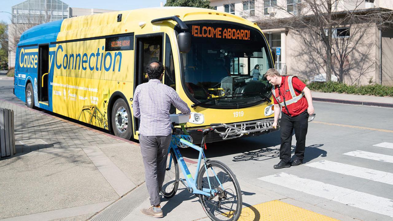Gold-and-blue bus, with "Welcome Aboard" in the message board above the windshield