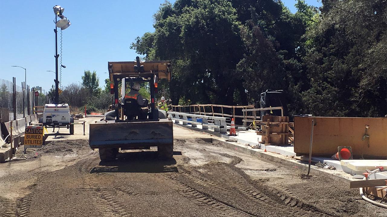 Construction workers grading dirt on the La Rue Road bridge.
