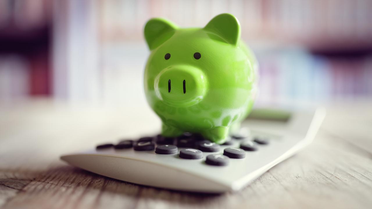 Piggy bank on top of calculator
