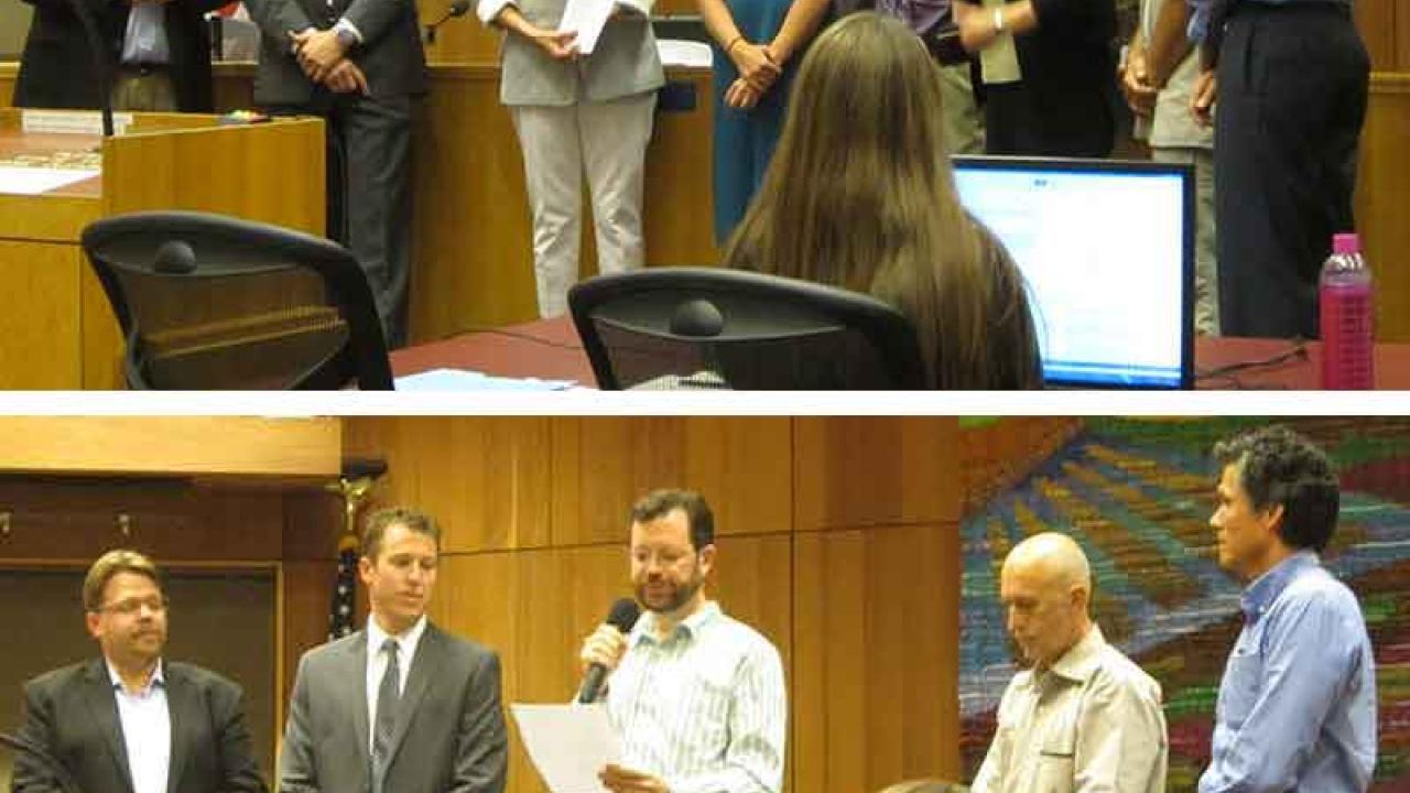 Photo: UC Davis representatives and Davis City Council members standing in front of the council dais.