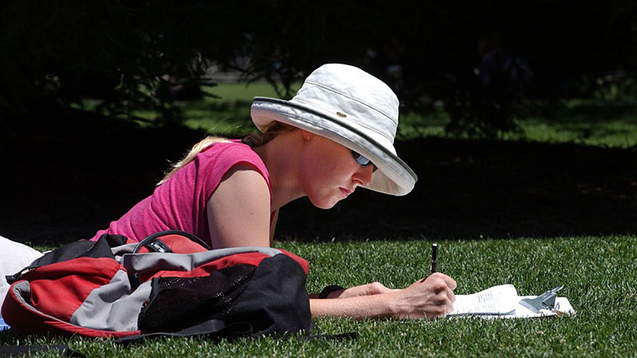 A female student studies on the Quad