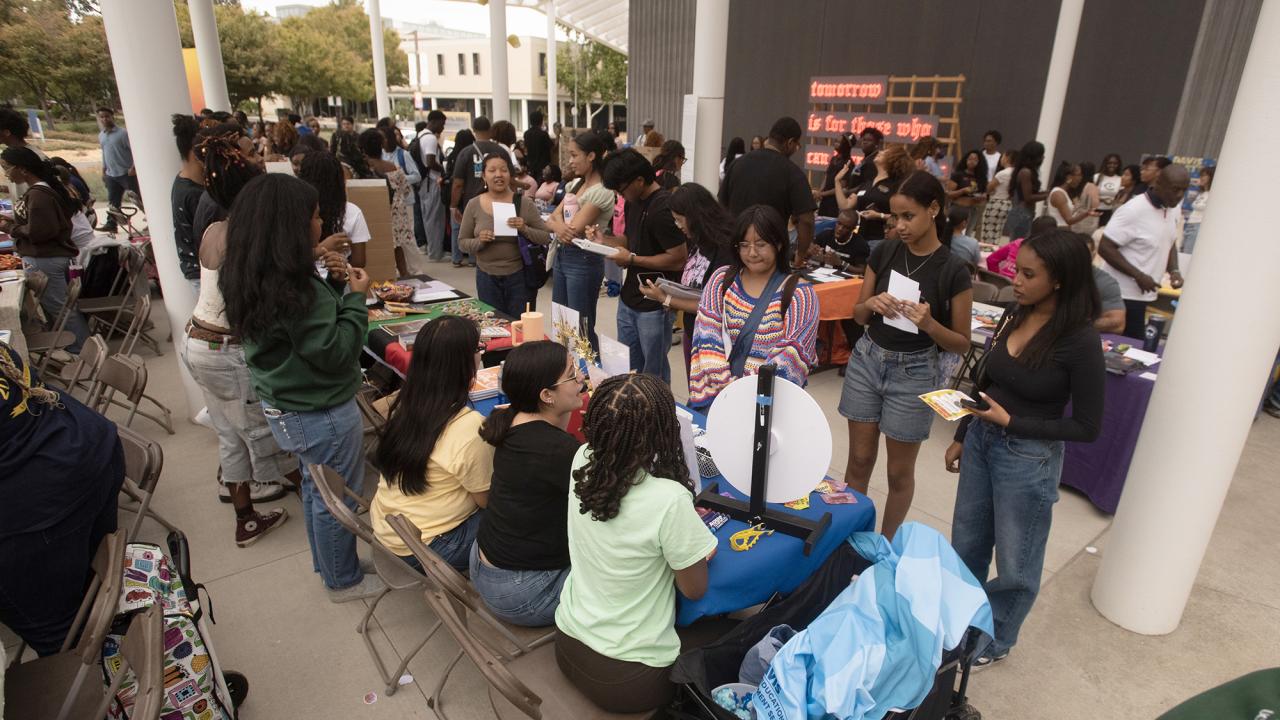 Large group of students vist tables on patio of Manetti Shrem Museum of Art