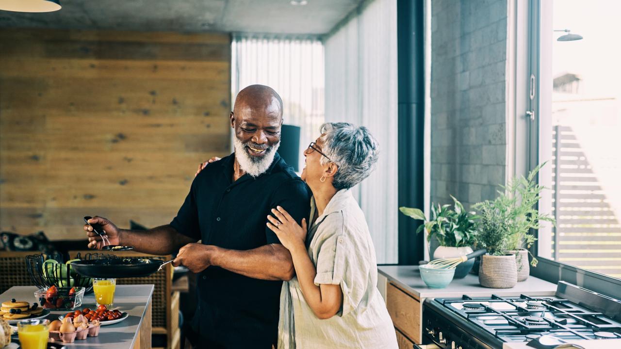 Couple cooking in kitchen smiling