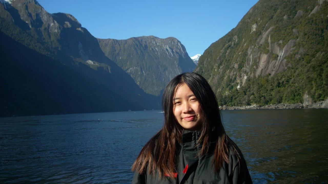 Student pictured in front of a picturesque New Zealand landscape