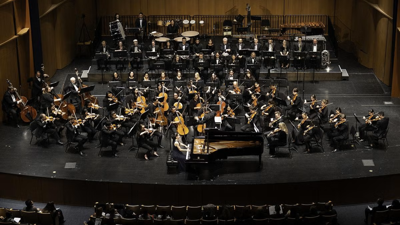 symphony orchestra on stage in darkened theater