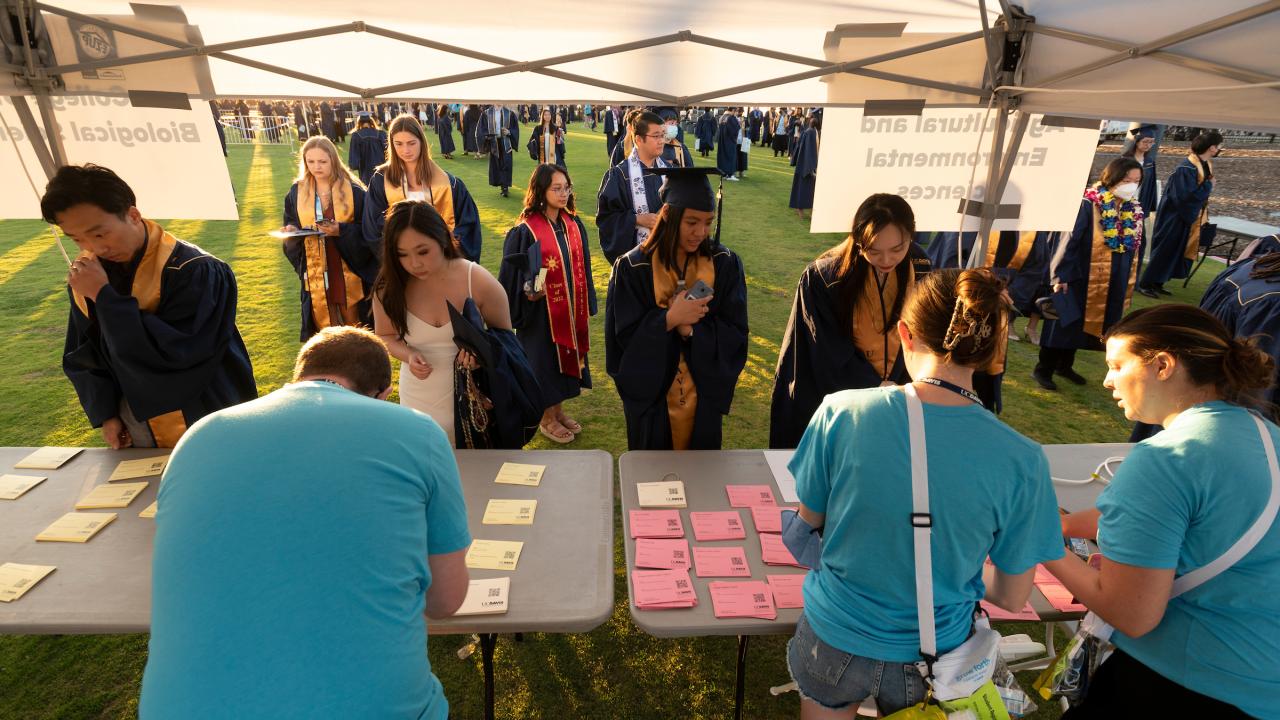 Commencement volunteers assist grads and their guests at a booth. 