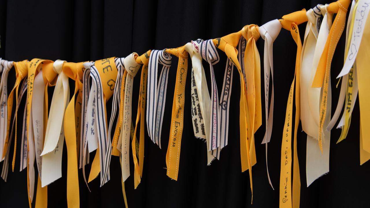 Yellow ribbons are tied to a memorial rope for the ribbon activity, which commemorates deceased loved ones. 
