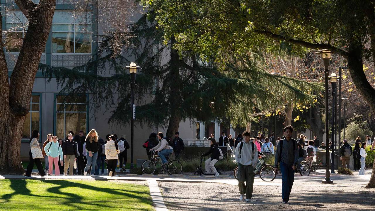 Students walk and ride bicycles outside Shields Library
