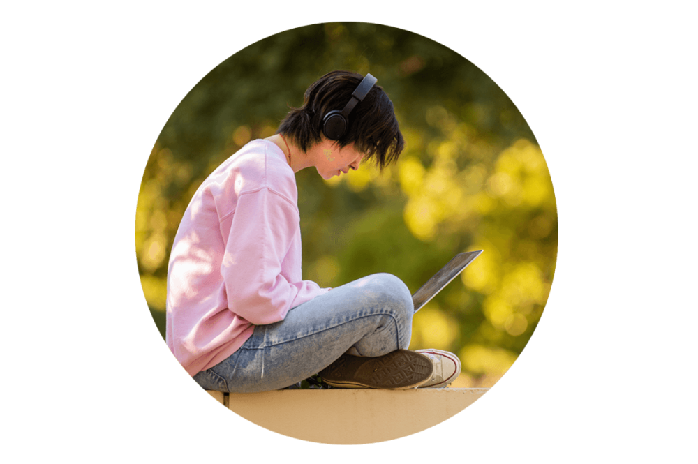 A student working on her laptop outdoors at the UC Davis campus