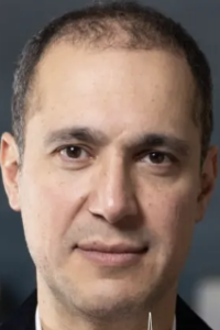 Headshot photograph of a middle-aged man with receding dark hair and neutral expression
