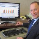 Photo: Provost Ralph J. Hexter, at computer monitor showing the provost's Dashboard