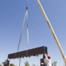 A crane lowers the Morris Fountain&acirc;s crossbeam into place as workers prepare to bolt it to the concrete pillars on July 27. Water will shoot up pipes in the columns, then fall in a sheet&acirc;like a theatre curtain&acirc;from the crossbeam. 