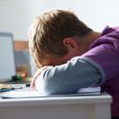 Boy with head on desk