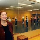 Photo: Professor Della Davidson in dance studio, students in mirror behind her