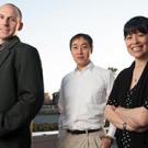 Two men and a woman posing in front of Rock Hall