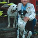 Photo: man sitting on porch with two dogs