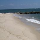 Beach and waves with platforms on the ocean in the background