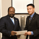 Associate Executive Vice Chancellor Rahim Reed, left, and student Steven Lee discuss the final draft of the Principles of One Community. The document is separate from the campus&rsquo;s Principles of Community, seen on the wall behind the men. It wa