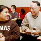 Francisco Samaniego enjoys a celebratory piece of cake while chatting with student Khemera Saman.