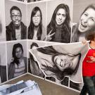 Student puts posters up on a building wall.