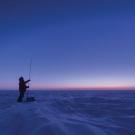 A man stands on a snowy plain